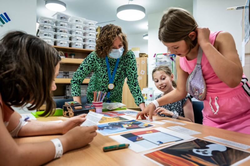 Juf helpt kinderen in een klas van Ziekenhuisschool Antwerpen